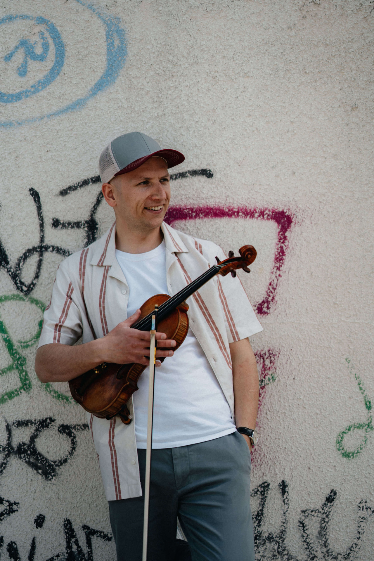 Pouliční muzikant hraje na housle před historickou budovou